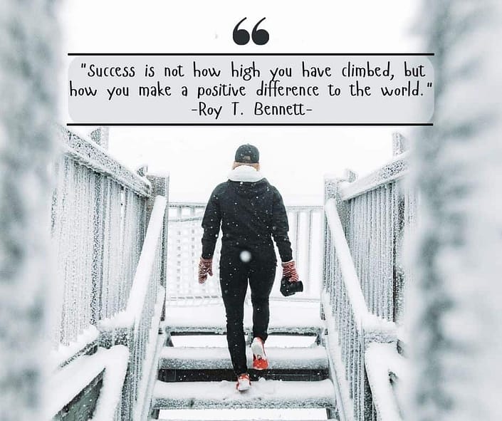 A woman walking up stairs in the snow with the quote from Roy T Bennett "Success is not how high you have climbed, but how you make a positive difference to the world."
