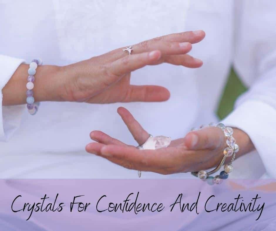 A lady holding a crystal in her hands with a text banner with the words Crystals for Confidence and Creativity